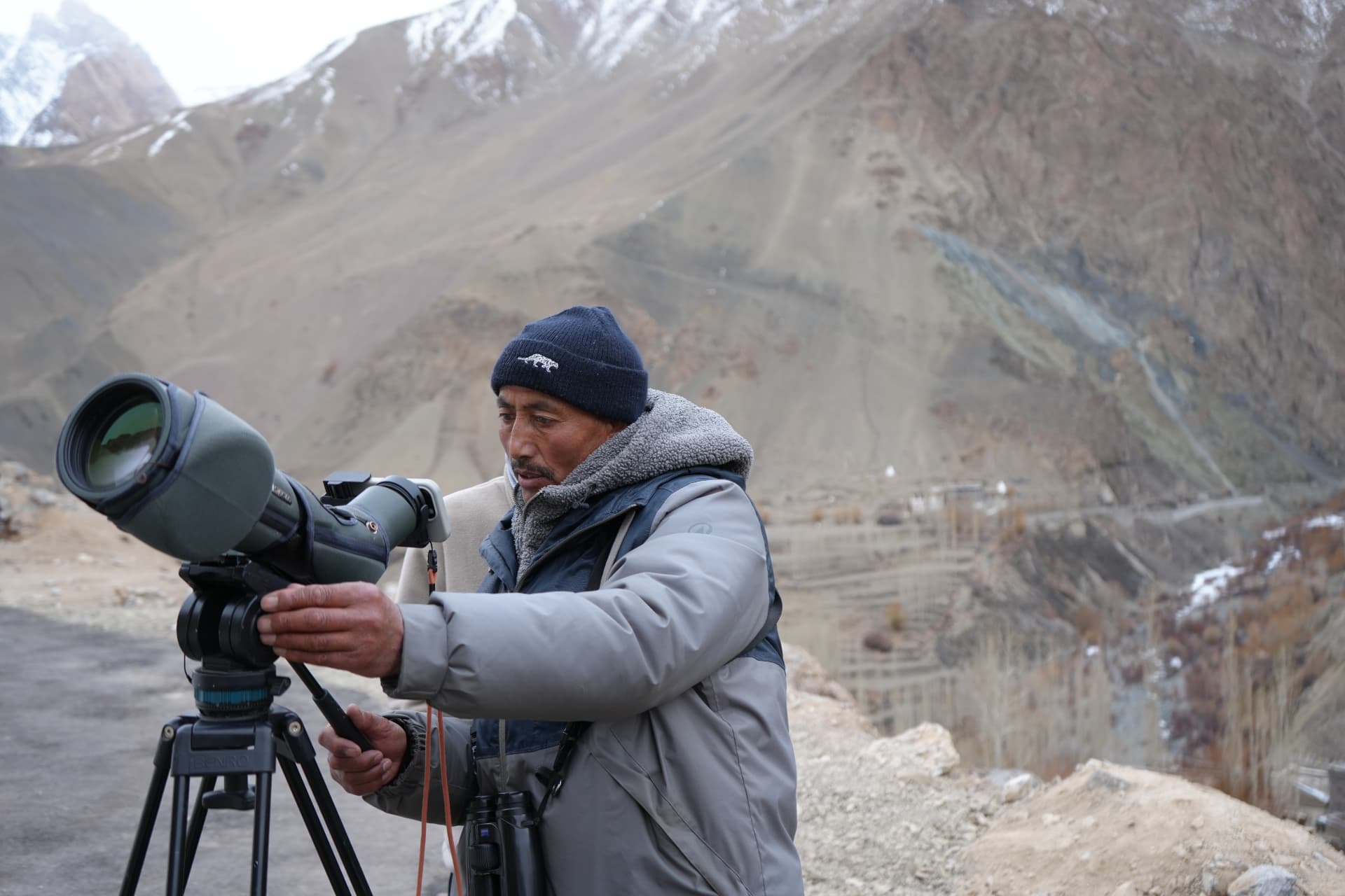 A local guide setting up a spotting scope above the valley