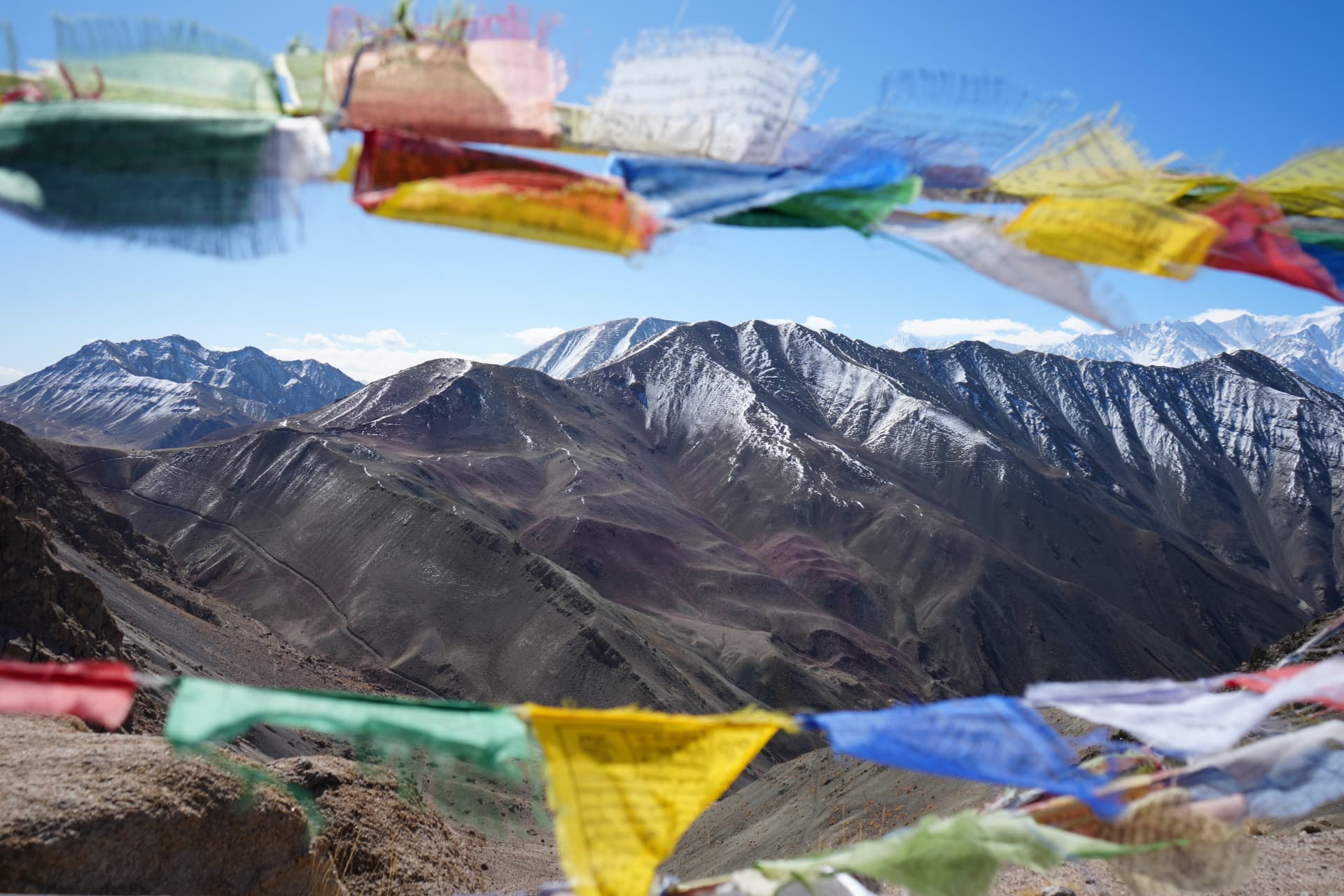 Prayer flags framing the snow-covered Himalayan range